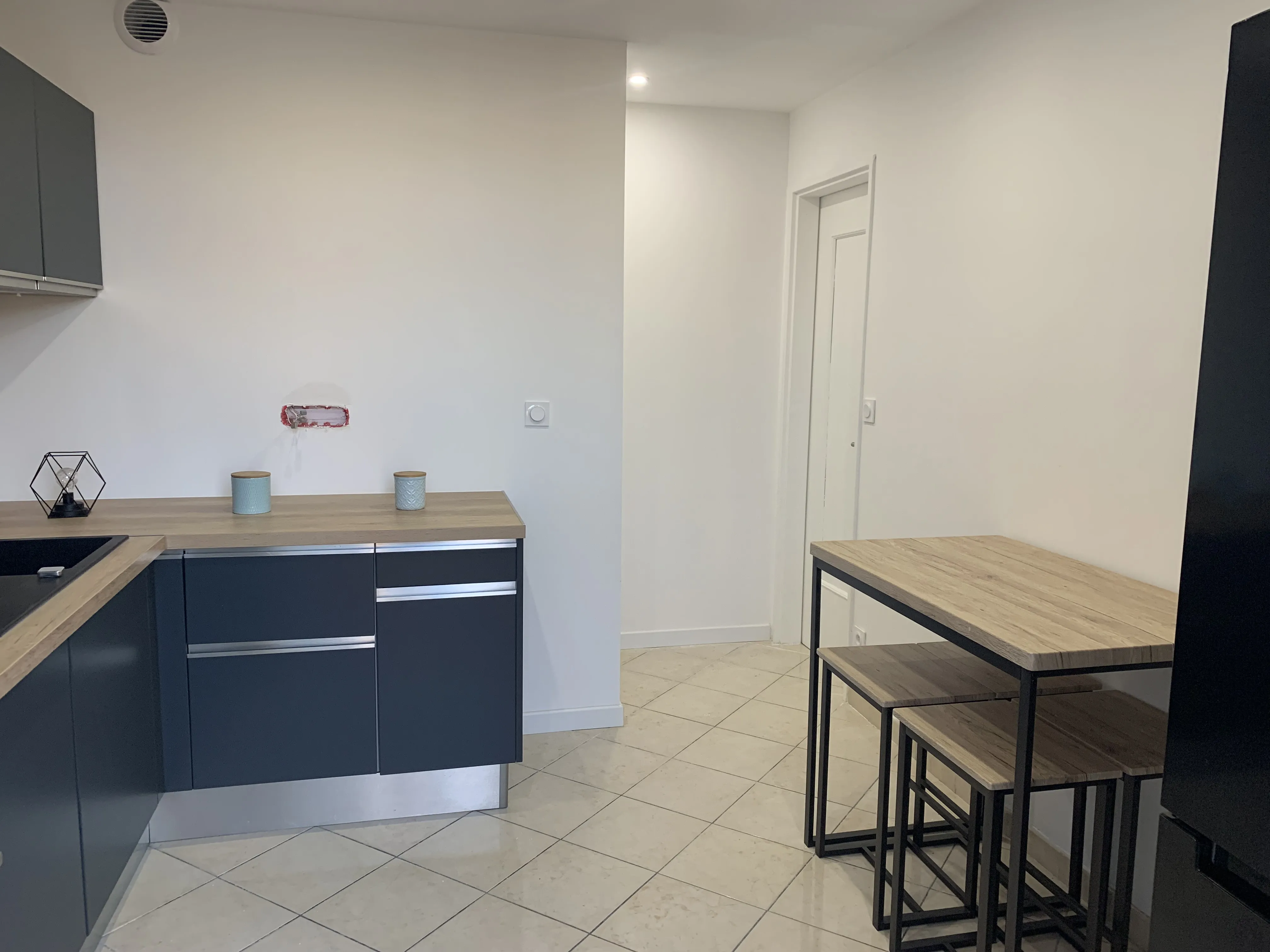 Plan de travail, lave-vaisselle et coin repas avec bar