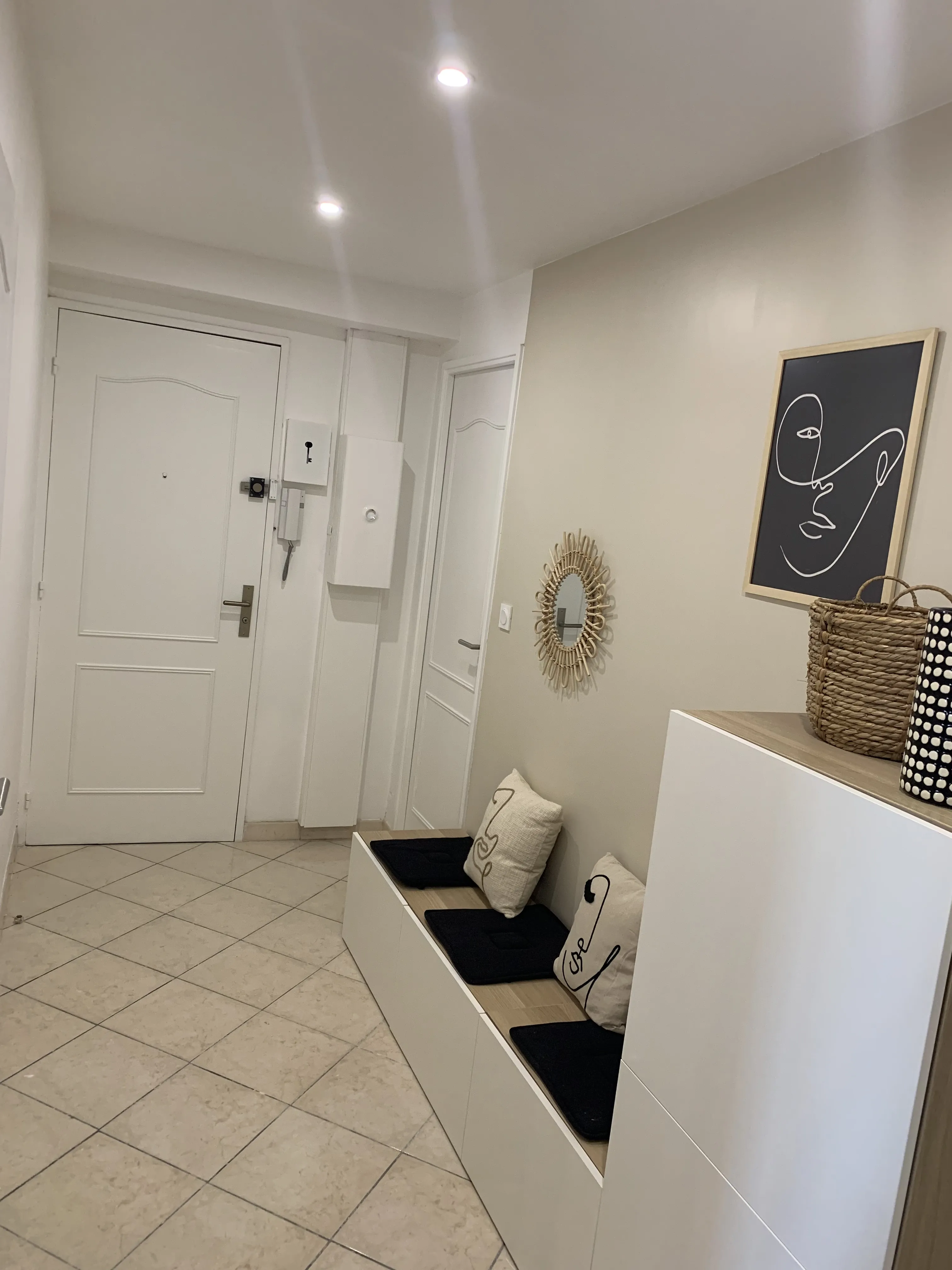 Hall d'entrée côté porte, meuble à chaussures et tableau